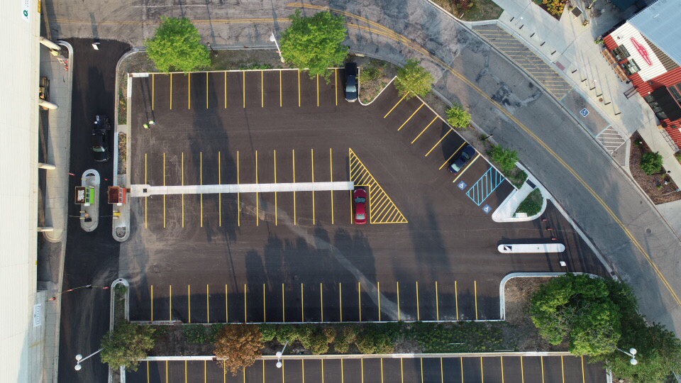 Aerial striped parking lot with yellow stalls and ADA spaces