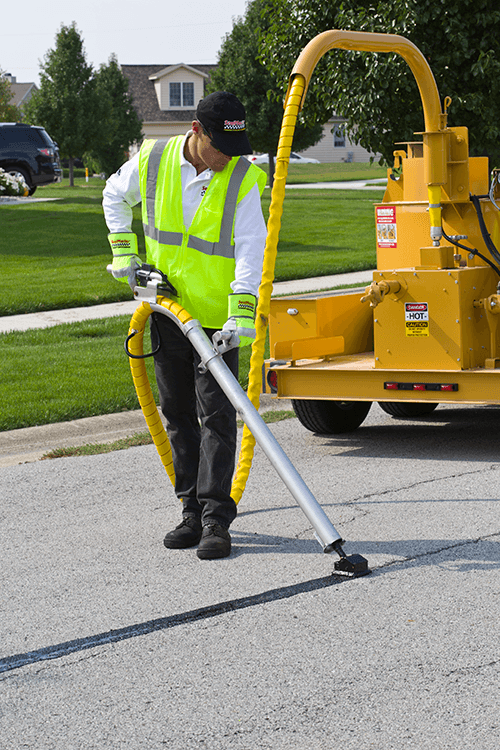 Crew crack-sealing a residential street with SealMaster equipment